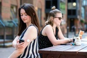 A woman using a flash glucose monitor.