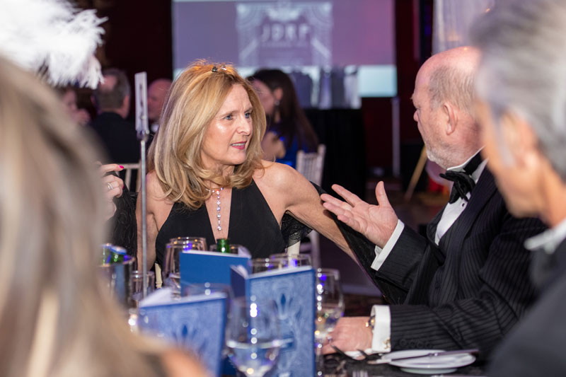 A woman and man in evening wear talking at a Breakthrough T1D UK gala ball
