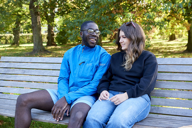 A man and woman sitting on a park bench together talking about type 1 diabetes