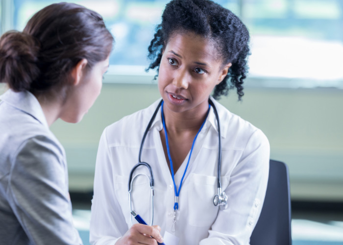 A doctor speaks to a female patient