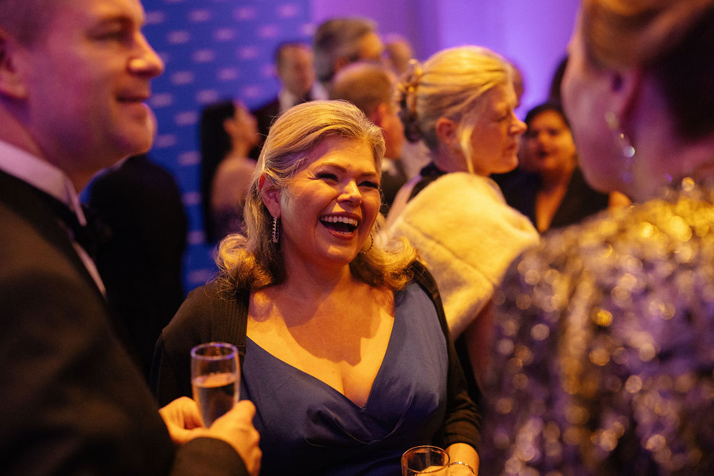 Group of friends with beverages laughing together at the ball