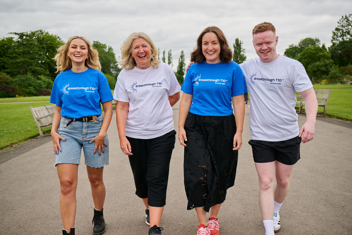 Three women one man walking in park all smiling and wearing Breakthrough T1D T-shirts