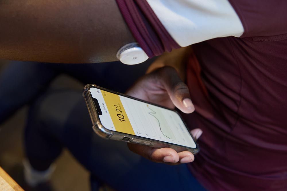 Close up of a man using his flash glucose monitor