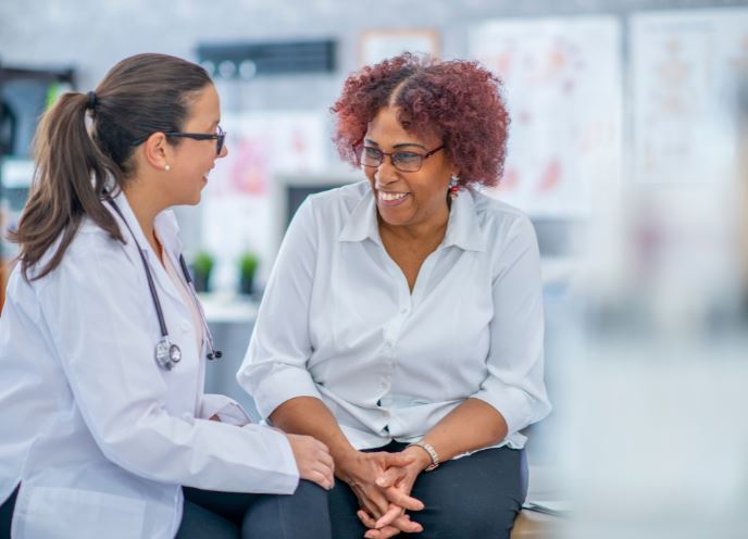 Female doctor with smiling patient in clinic setting