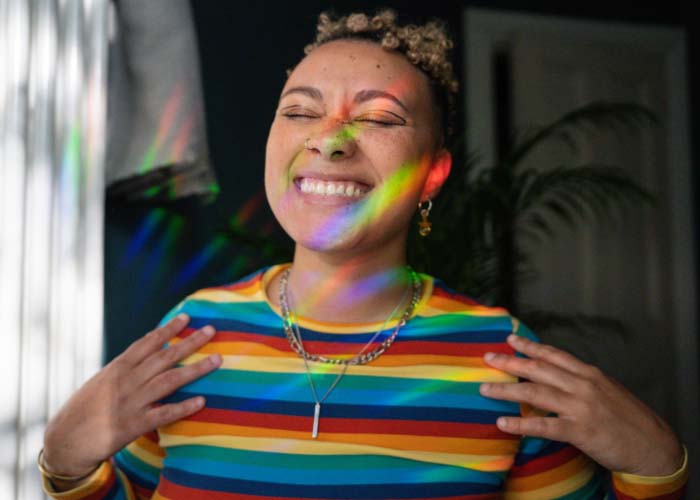 Woman in striped top smiling with eyes closed.
