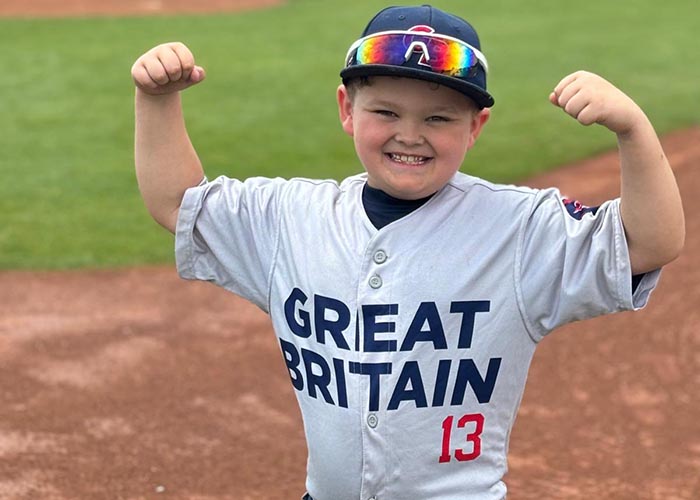 9 year old Mason Barnaby in his Great Britain baseball shirt, doing a 'strongman' pose.