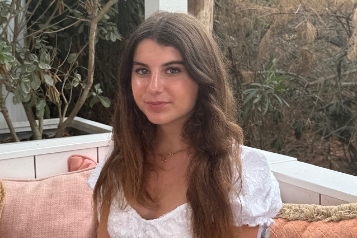 A young woman with type 1 diabetes sitting on a sofa looking at the camera