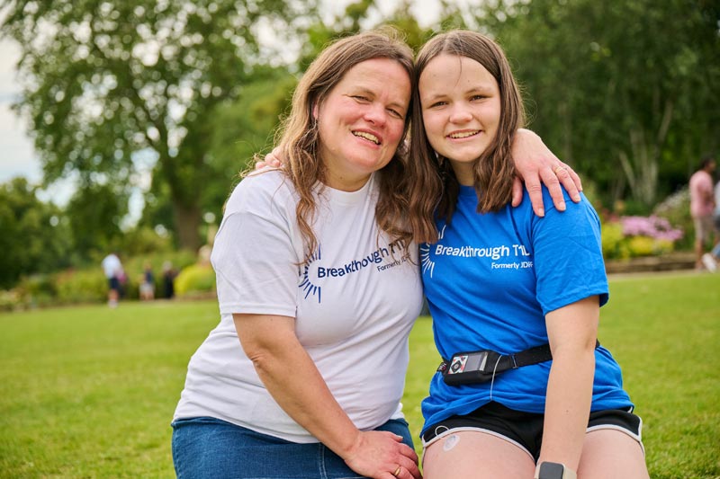 Mother and daughter with type 1 diabetes in a park with Breakthrough T1D tops