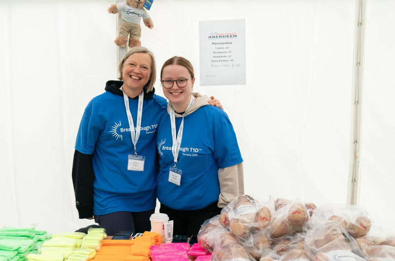 Two volunteers at a stall for One Walk Aberdeen
