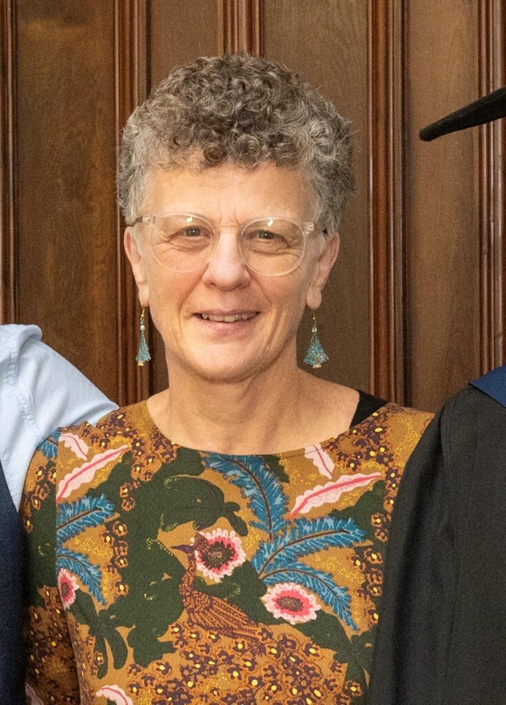 A lady with short hair smiling at the camera