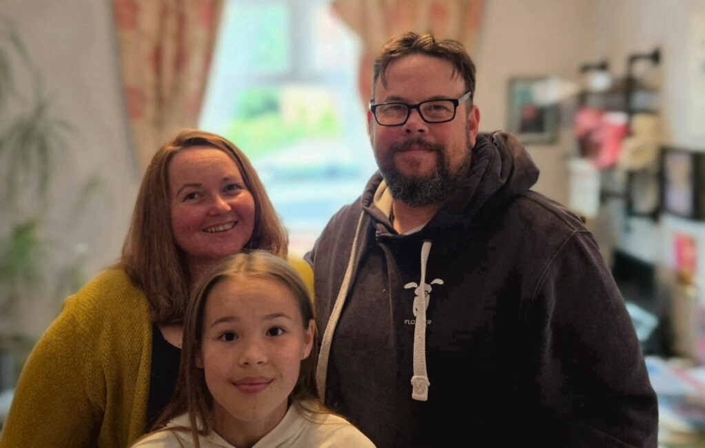 image showing mother, daughter and father smiling at the camera