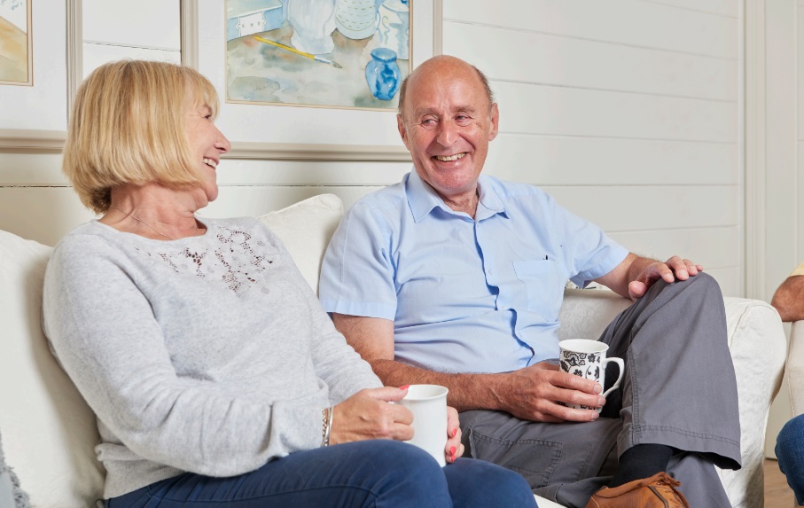 Older man sitting with woman drinking tea