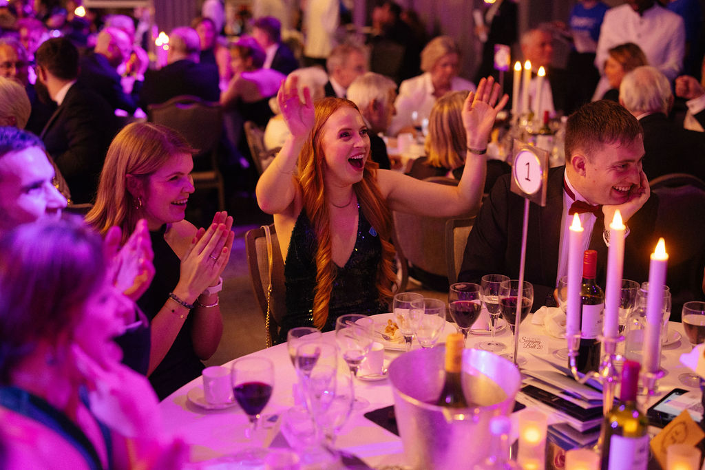 A group of smiling people sat at a table during a Breakthrough T1D ball event.