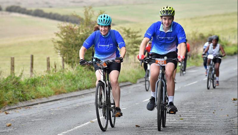 Two cyclists riding in countryside in the London to Brighton Cycle event.