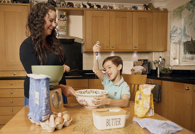 Mother and child baking together in kitchen