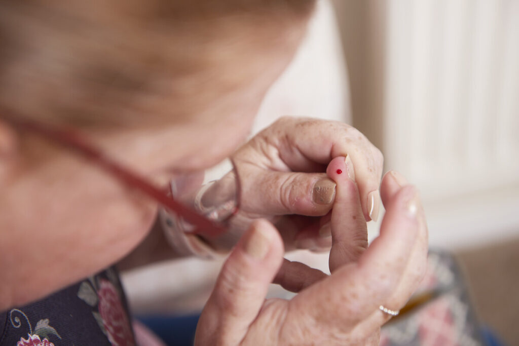 Woman with blood on finger tip for blood test