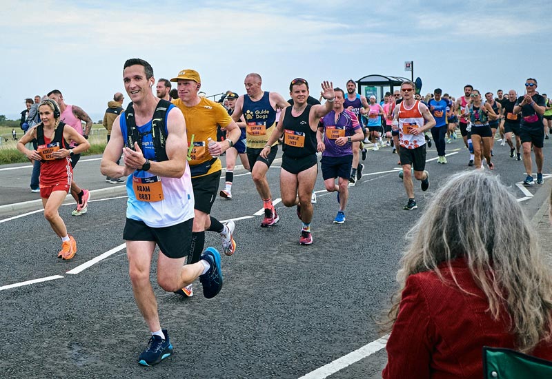 Marathon runners on road with bus stop in background raising money for type 1 diabetes