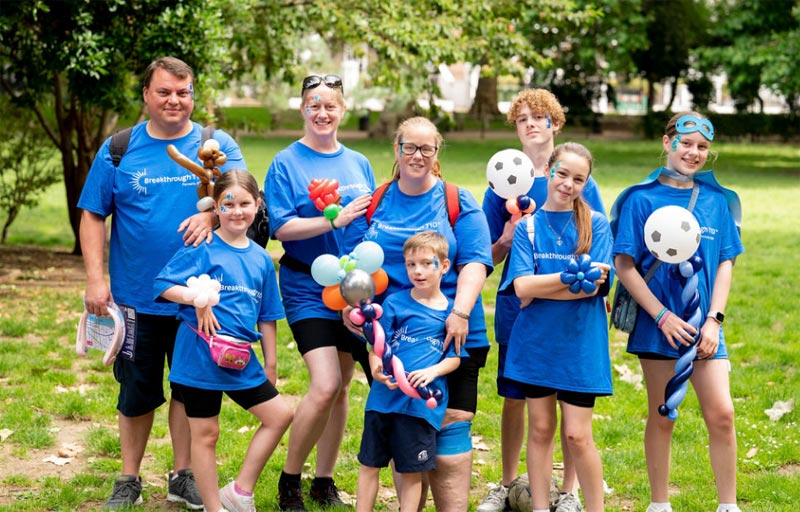 A large family group in the park wearing Breakthrough T1D T-shirts while participating in One Walk to raise money for type 1 diabetes.