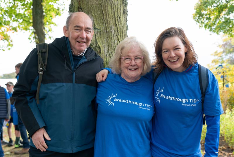 Older man and woman with younger woman in park taking part in Breakthrough T1D's One Walk to raise money for type 1 diabetes