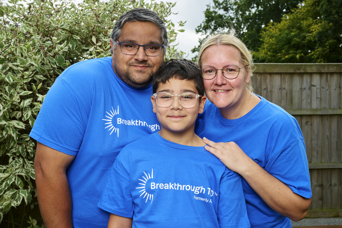 Mother, father and son in Breakthrough T1D shirts in the garden.